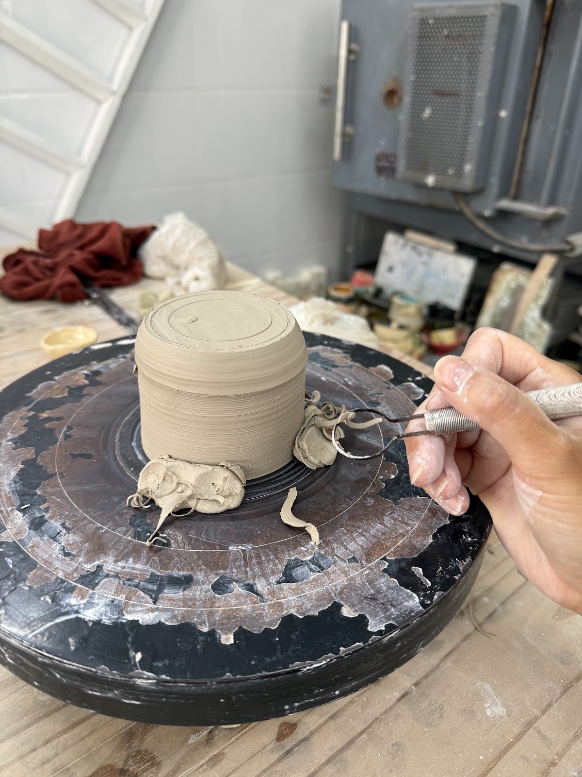 Trimming a piece on the wheel in the studio